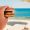 Holding a burger by the sea before going for a swim