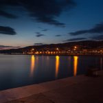 Night view of Lefkada Town promenade with lights reflecting on the sea
